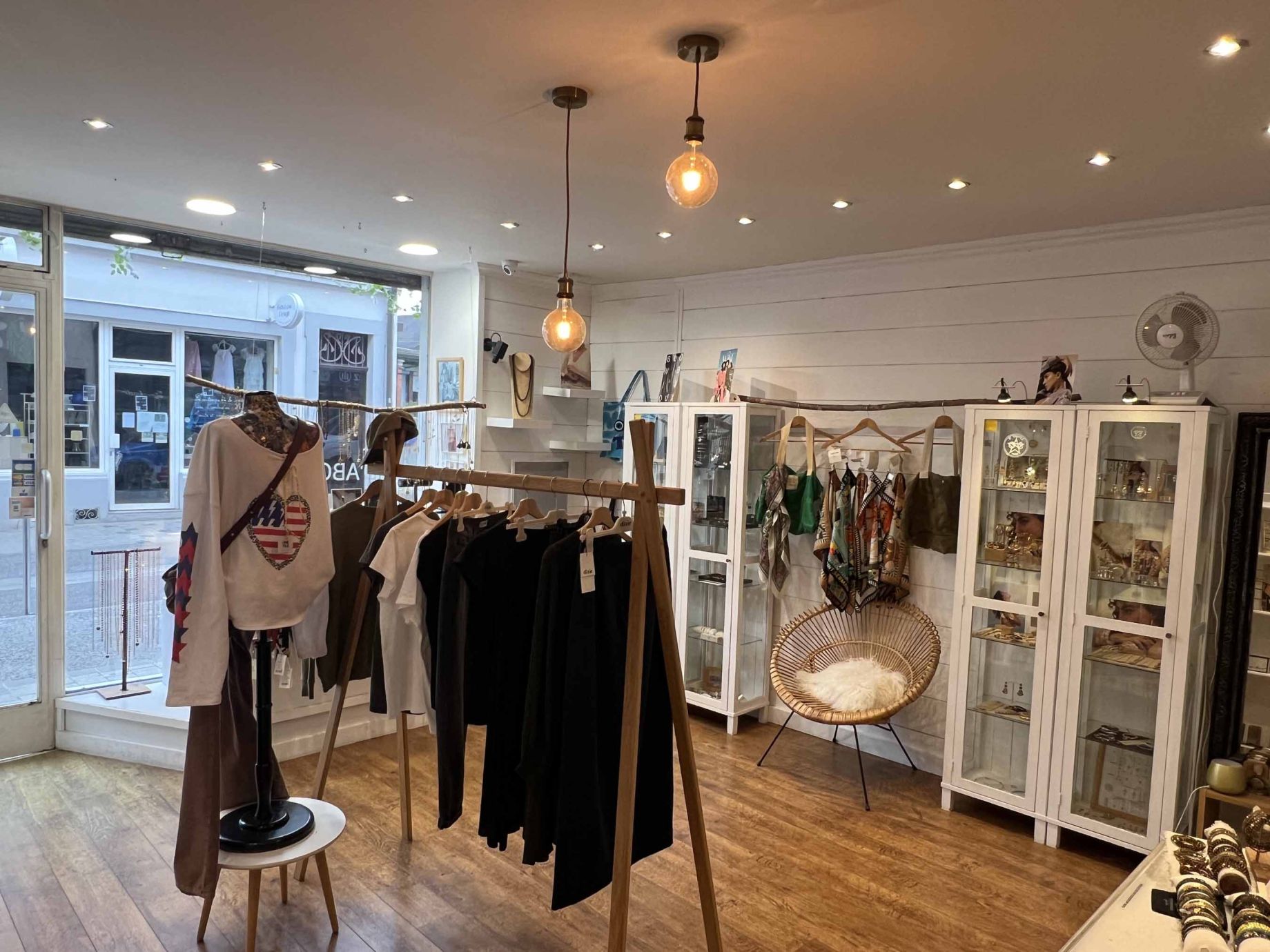 Vue intérieure de la boutique Moi d'Abord à Divonne-les-Bains, mettant en avant une sélection de vêtements, bijoux et accessoires de créateurs.
