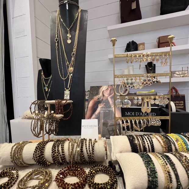 Sélection de colliers et bracelets exposés sur un présentoir en bois chez Moi d'Abord à Divonne-les-Bains. Bijoux créateurs raffinés en or et pierres naturelles.