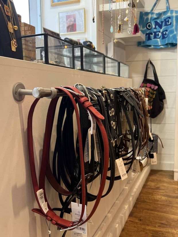Sélection de ceintures en cuir noir, marron et rouge, présentées en boutique chez Moi d'Abord à Divonne-les-Bains.