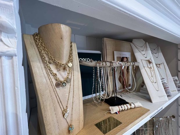 Sélection de colliers et bracelets exposés sur un présentoir en bois chez Moi d'Abord à Divonne-les-Bains. Bijoux créateurs raffinés en or et pierres naturelles.