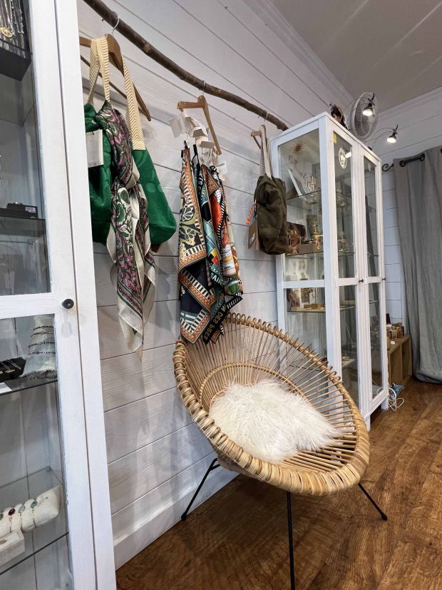 Espace cosy dans la boutique Moi d'Abord à Divonne-les-Bains, mettant en valeur des foulards, sacs et accessoires aux imprimés colorés.